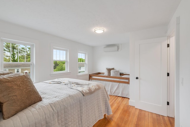 12 Dartmouth St, Hyannis, MA 02601 - bedroom with an AC wall unit, multiple windows, and light wood finished floors