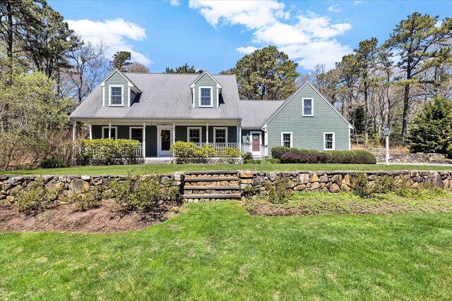 cape cod house with covered porch and a front yard