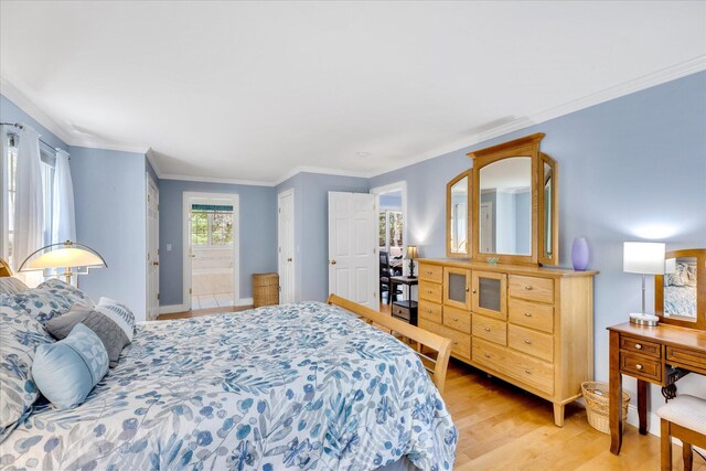 bedroom featuring light wood-type flooring, ornamental molding, and baseboards