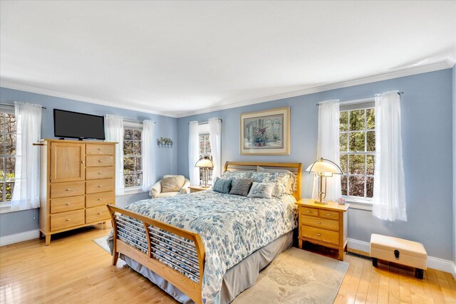 bedroom with baseboards, crown molding, and hardwood / wood-style floors