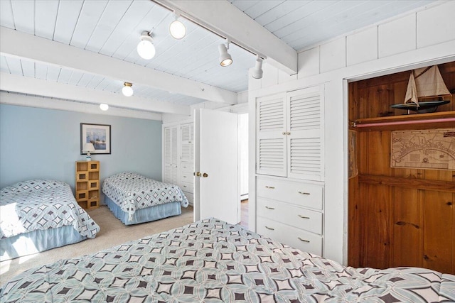 bedroom featuring carpet, beam ceiling, wooden ceiling, and rail lighting