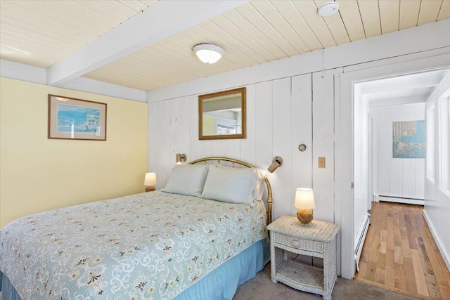 bedroom featuring a baseboard radiator, a baseboard heating unit, wood finished floors, wooden ceiling, and beamed ceiling