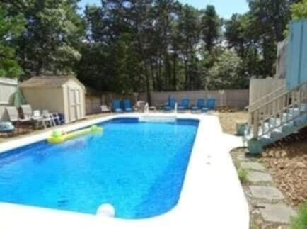 view of swimming pool featuring a patio, a fenced backyard, a storage shed, an outdoor structure, and a fenced in pool