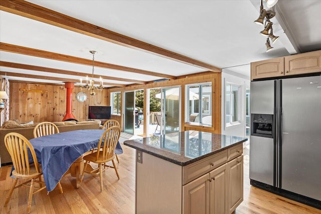 kitchen with beam ceiling, light wood finished floors, open floor plan, a kitchen island, and stainless steel fridge with ice dispenser