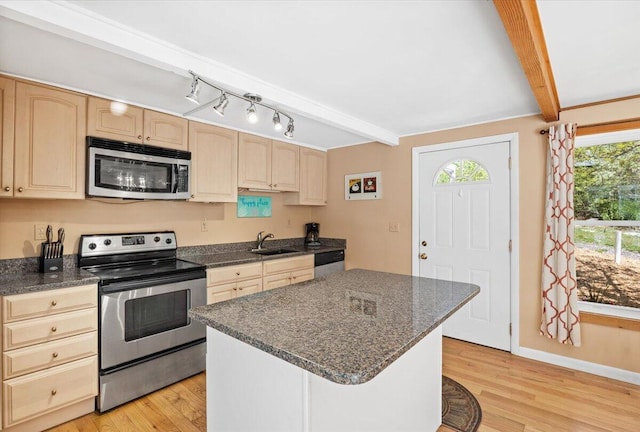 kitchen with beam ceiling, stainless steel appliances, a sink, and light brown cabinetry