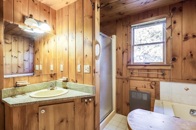 bathroom with tile patterned floors, wood walls, shower with separate bathtub, vanity, and radiator heating unit