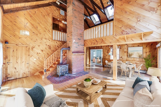 living room featuring a skylight, beam ceiling, and wooden walls