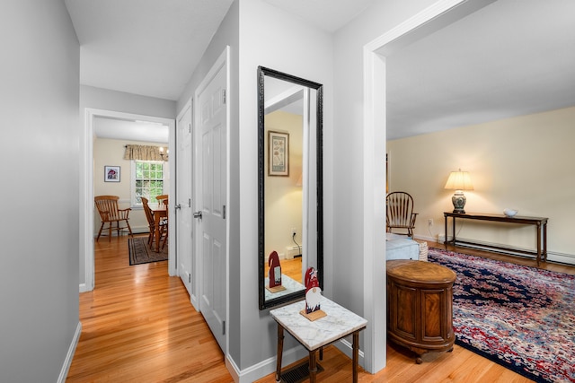 290 Riverview Ln, Centerville, MA 02632 - corridor with light wood finished floors, baseboards, and a baseboard radiator