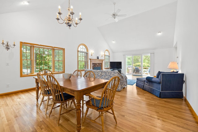 62-64 Old Fish House, South Dennis, MA 02660 - dining space with high vaulted ceiling, a fireplace, a chandelier, light wood-style flooring, and a ceiling fan