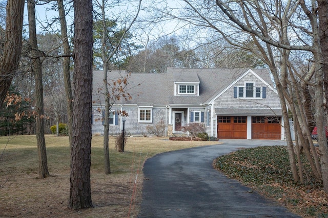 shingle-style home with a garage, a front lawn, and aphalt driveway