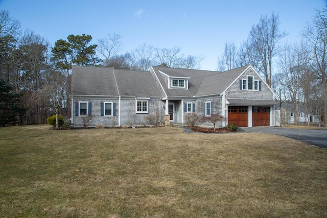 view of front of home featuring a garage, aphalt driveway, and a front yard