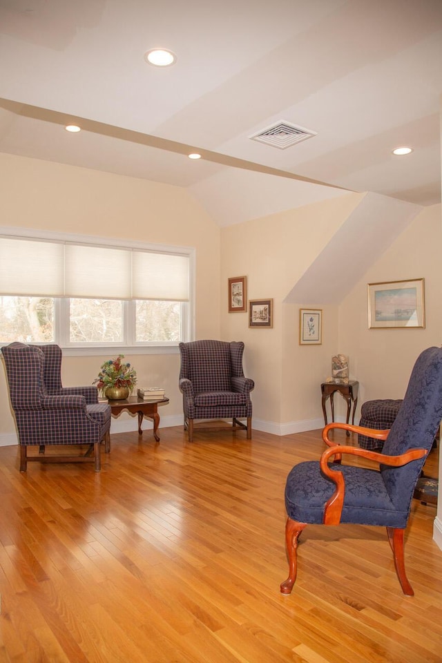 living area featuring lofted ceiling, light wood-style flooring, recessed lighting, visible vents, and baseboards