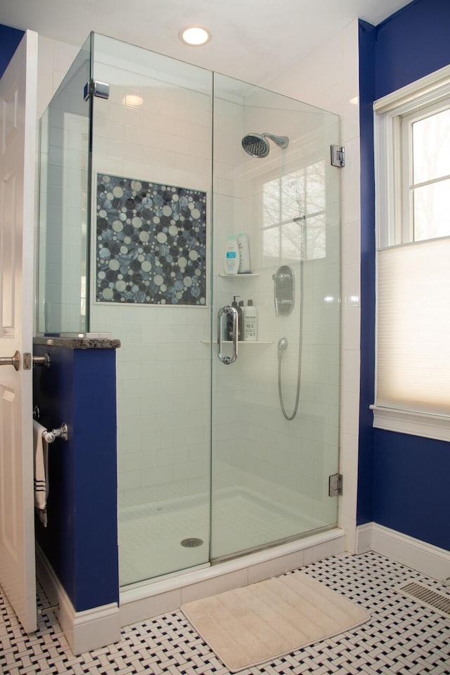 full bath with a stall shower, baseboards, and tile patterned floors