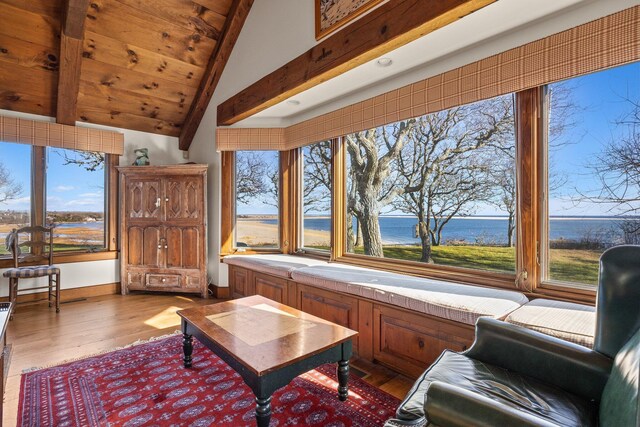 sitting room with wood finished floors, a water view, plenty of natural light, and wooden ceiling
