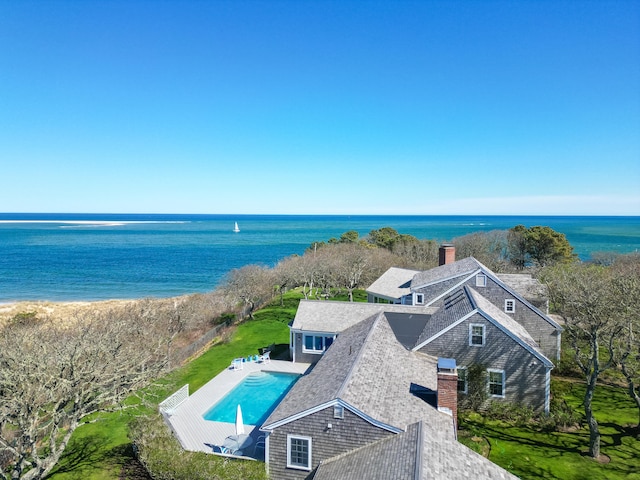 view of subject property with a pool area and a nearby body of water