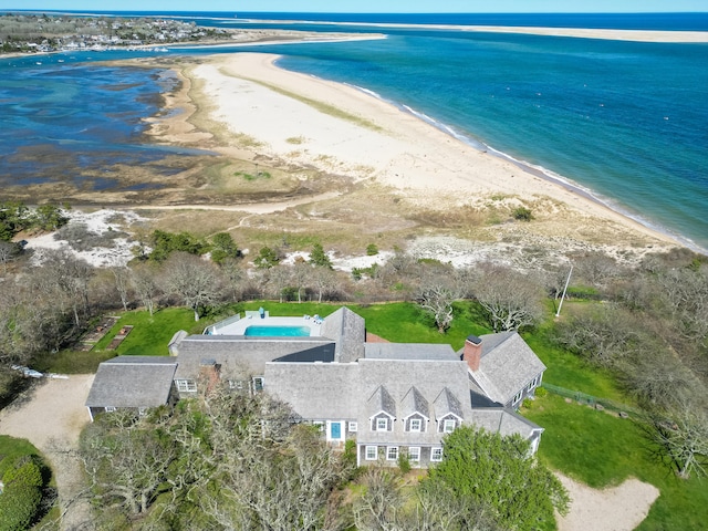 aerial view of property and surrounding area featuring waterfront with a beach