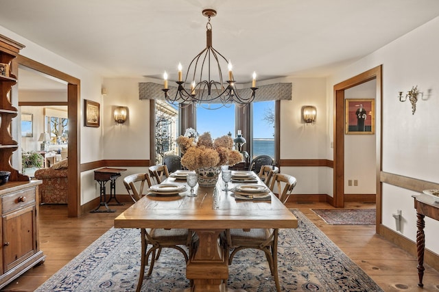 dining space featuring a chandelier, healthy amount of natural light, and wood finished floors