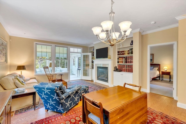 17 Chadwick Ct, Mashpee, MA 02649 - living room featuring wood finished floors, a chandelier, ornamental molding, a glass covered fireplace, and baseboards