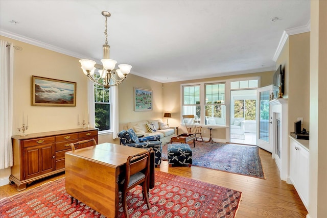 17 Chadwick Ct, Mashpee, MA 02649 - living area with ornamental molding, a chandelier, light wood-style floors, baseboards, and a fireplace