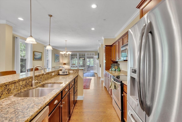 17 Chadwick Ct, Mashpee, MA 02649 - kitchen featuring stainless steel appliances, a sink, brown cabinets, ornamental molding, and a chandelier