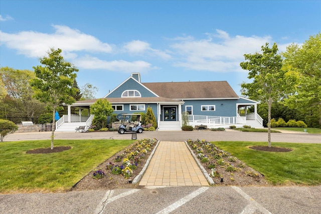 17 Chadwick Ct, Mashpee, MA 02649 - view of front of house with a porch, a front lawn, and a chimney