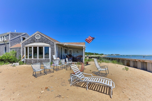 rear view of house featuring a water view and a patio area