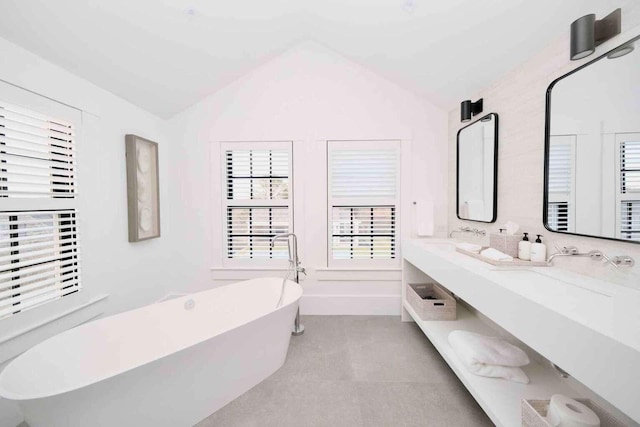 bathroom with a bathtub, vanity, and lofted ceiling