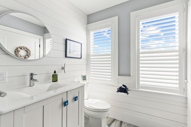 494 Shore Rd, North Truro, MA 02652 - half bath featuring toilet, wooden walls, vanity, and wood finished floors