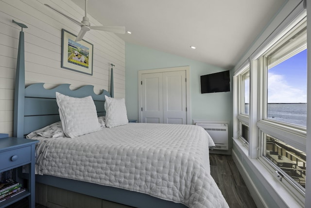 bedroom with vaulted ceiling, dark wood finished floors, a closet, heating unit, and recessed lighting