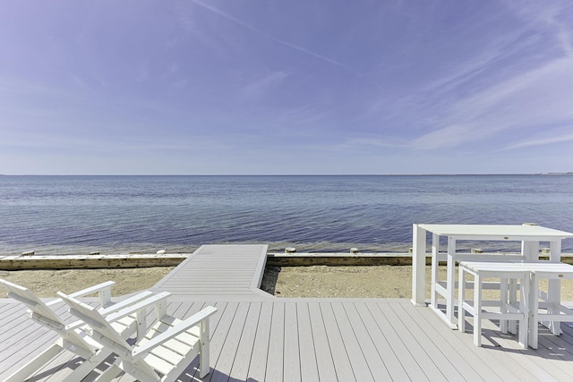 view of dock with a deck with water view and a view of the beach