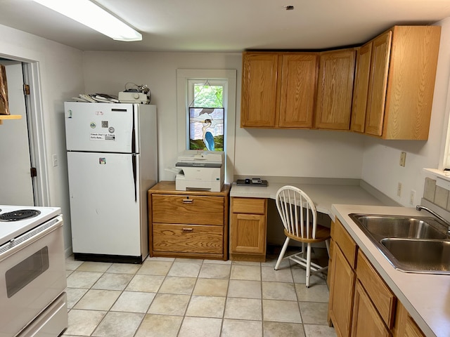 kitchen featuring sink, white appliances, and built in desk