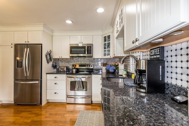 480 Forest Rd, South Yarmouth, MA 02664 - kitchen with appliances with stainless steel finishes, white cabinets, glass insert cabinets, wood finished floors, and tasteful backsplash