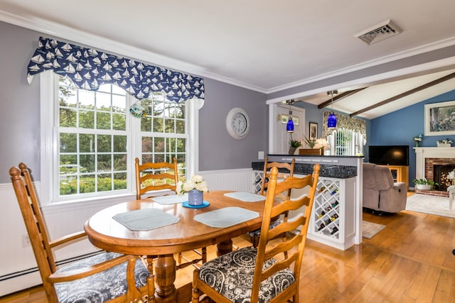 480 Forest Rd, South Yarmouth, MA 02664 - dining space with hardwood / wood-style flooring, healthy amount of natural light, wainscoting, a brick fireplace, and ornamental molding