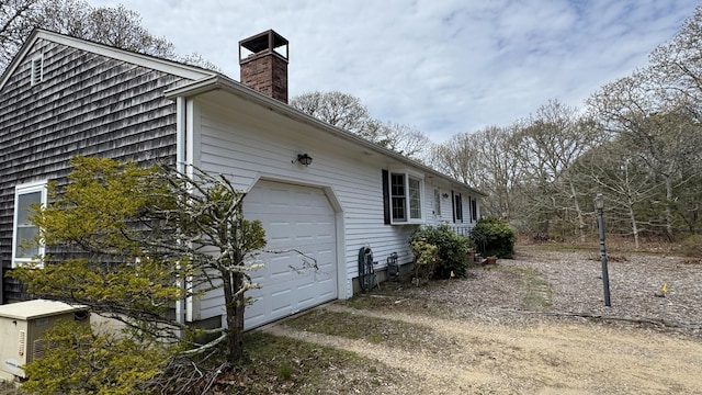 view of property exterior with a chimney and an attached garage