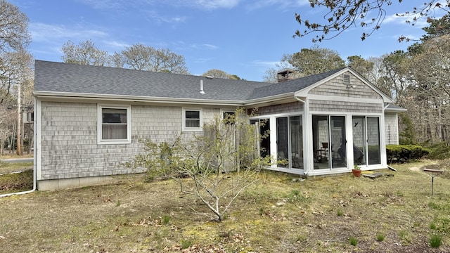 back of property featuring roof with shingles, a sunroom, and a chimney