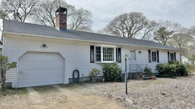 single story home featuring driveway, a chimney, an attached garage, and a shingled roof