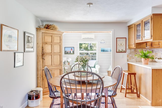 dining space with baseboards and light wood-style flooring