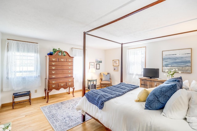 bedroom featuring baseboards and wood finished floors