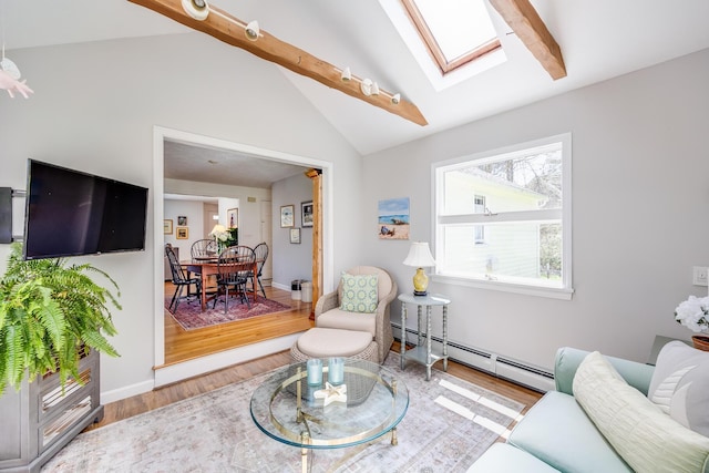 living area with vaulted ceiling with skylight, baseboards, a baseboard radiator, and wood finished floors