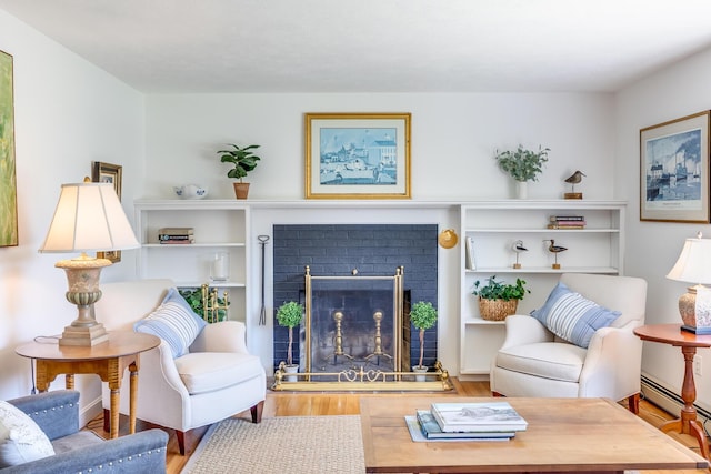 living room featuring a baseboard radiator, wood finished floors, and a fireplace