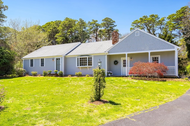 ranch-style home with a chimney and a front yard