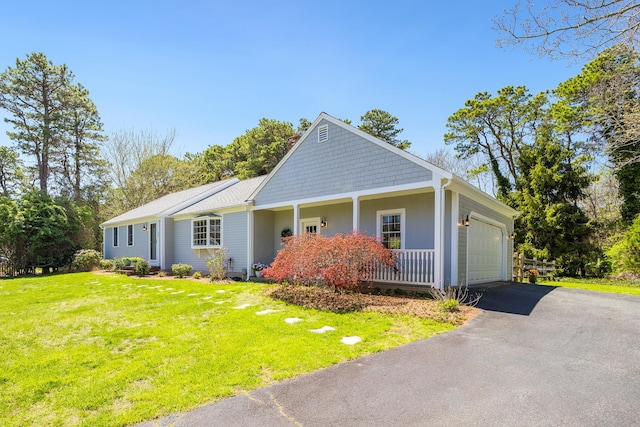 view of front of property featuring a garage, covered porch, a front lawn, and aphalt driveway