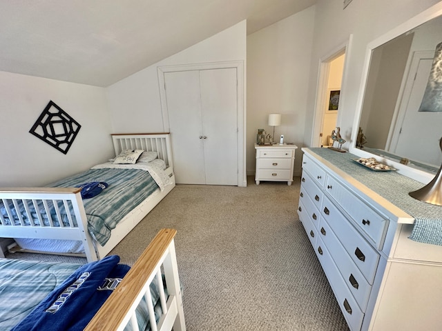 carpeted bedroom with a closet and vaulted ceiling