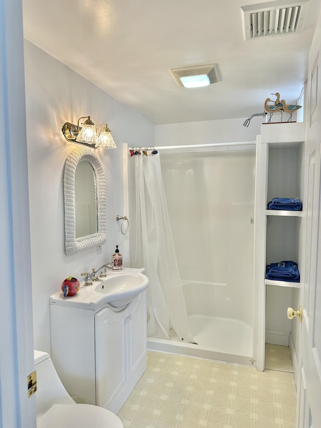 bathroom with vanity, toilet, and walk in shower