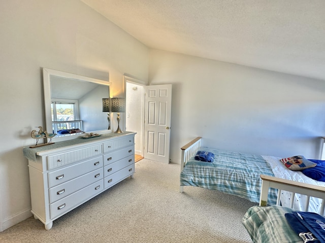 carpeted bedroom with a textured ceiling and lofted ceiling