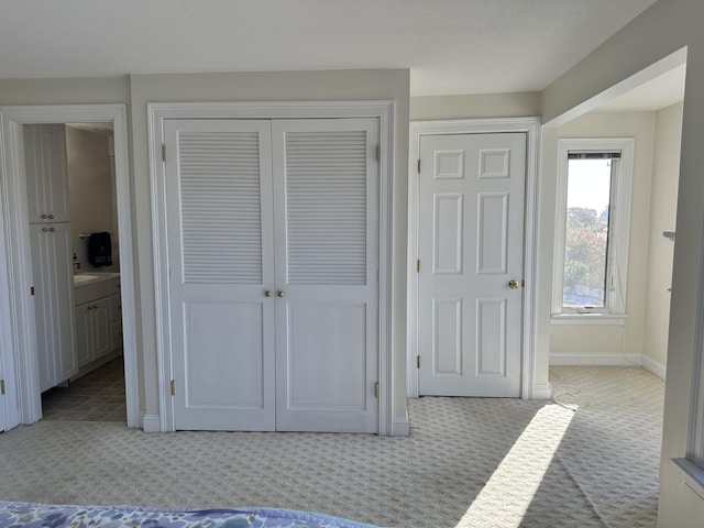 carpeted bedroom featuring ensuite bath