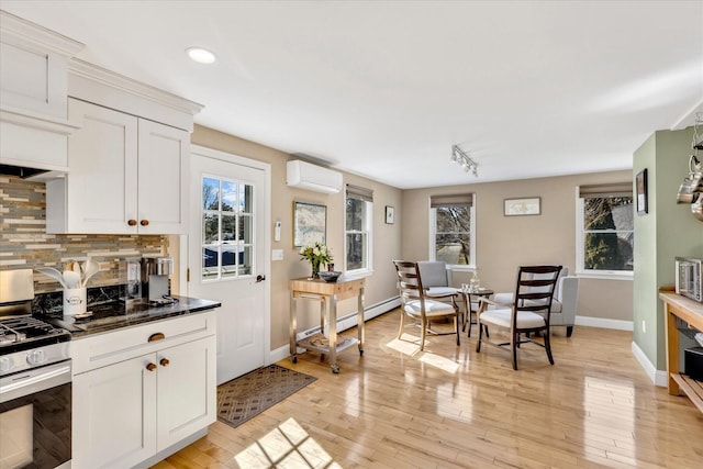51 Buccaneer Way, Mashpee, MA 02649 - kitchen featuring stainless steel range with gas cooktop, a wall mounted air conditioner, dark countertops, decorative backsplash, and white cabinetry