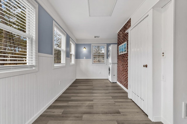 hallway with stacked washer and dryer and dark hardwood / wood-style floors