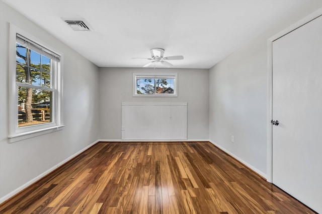 unfurnished room featuring ceiling fan and dark hardwood / wood-style flooring