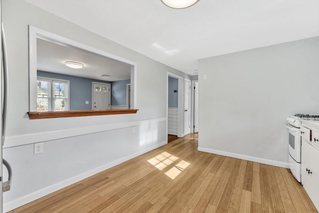 kitchen with white cabinetry, white range with gas cooktop, and light hardwood / wood-style flooring